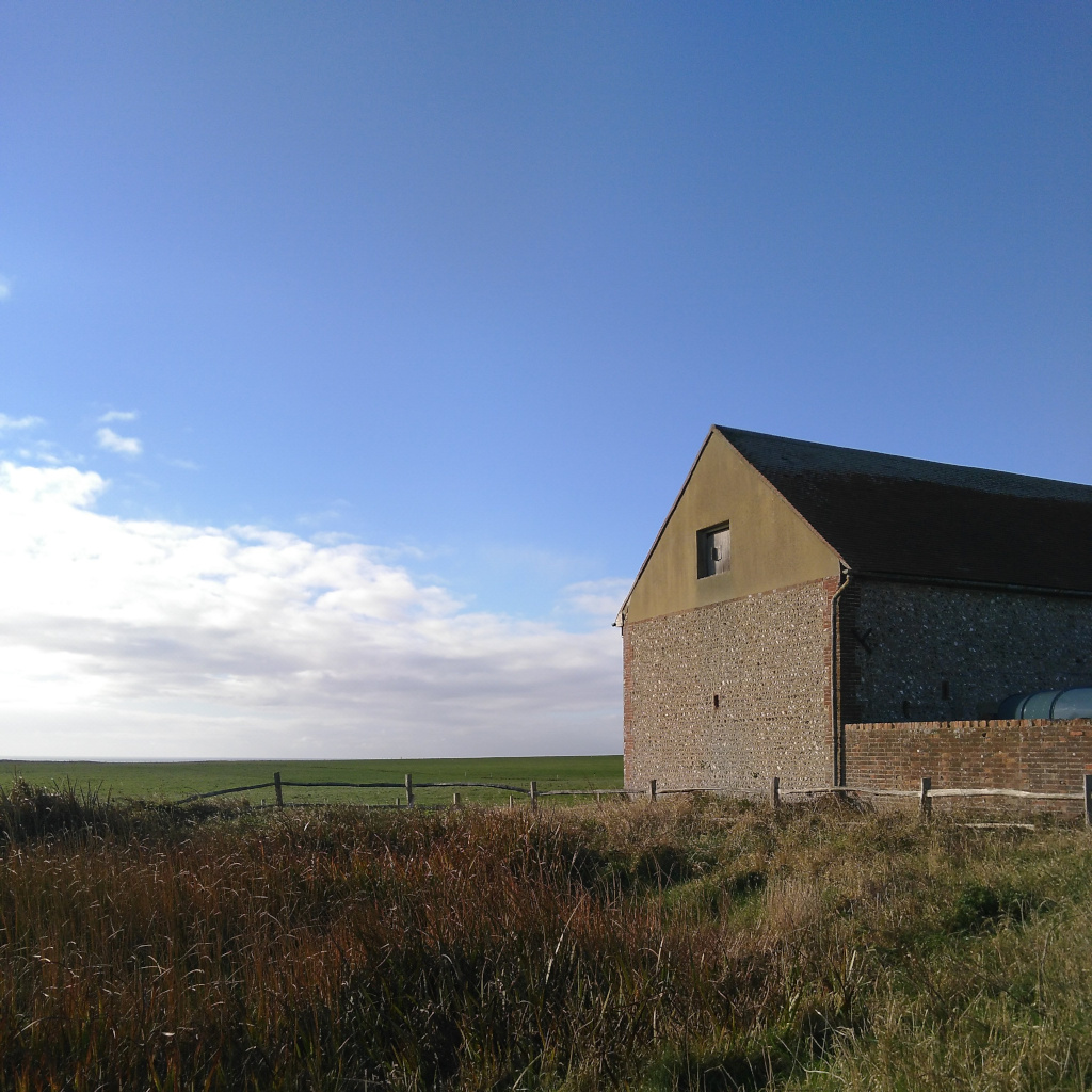 A brick barn set against a blue sky