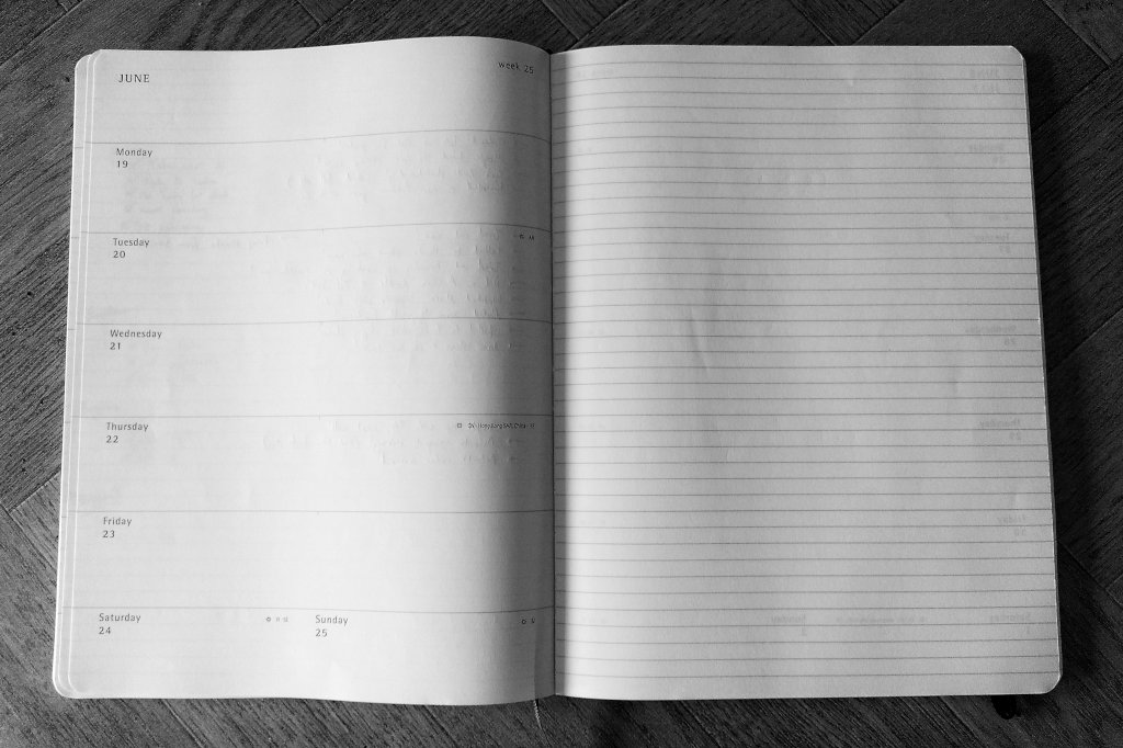 Black and white photo of a double-page spread of an empty planner book, opened at a week in June.